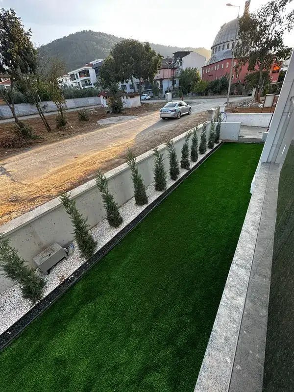 Duvar boyunca servi dizisi ve çim şerit